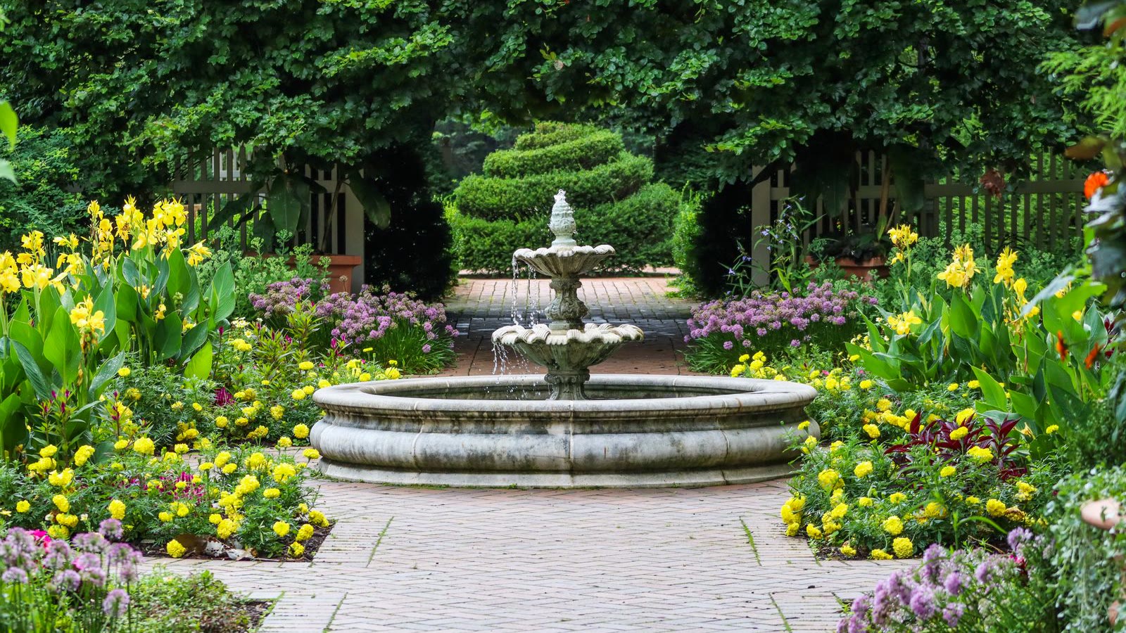 Formal flower garden with a central stone fountain